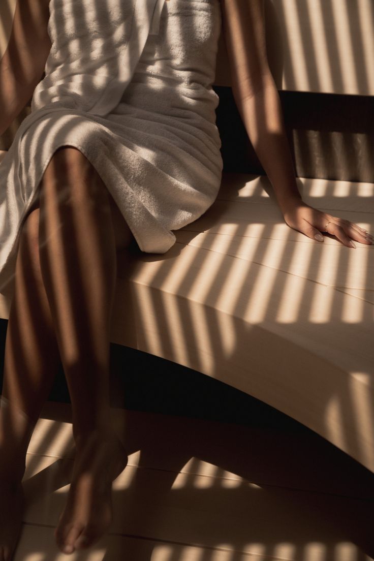 Warm light falling across a person seated in a sauna.